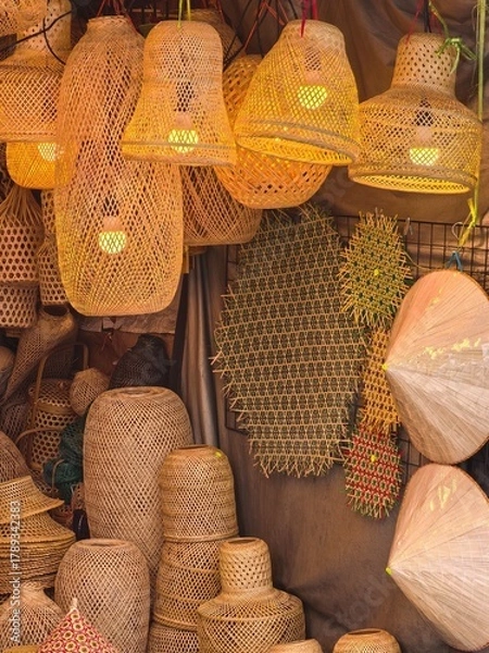 Obraz Handmade woven lampshades and hats on display in a market stall