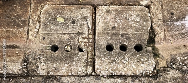 Obraz Close-up of a weathered concrete drain cover with circular holes
