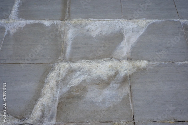 Fototapeta Efflorescence stain on concrete wall or floor surface showing salt deposits and moisture damage texture, Limestone stains on tile floor