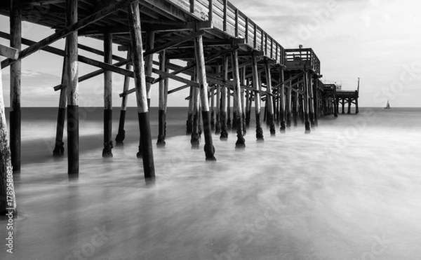 Fototapeta Smooth waves float past the pier at Balboa Island, California
