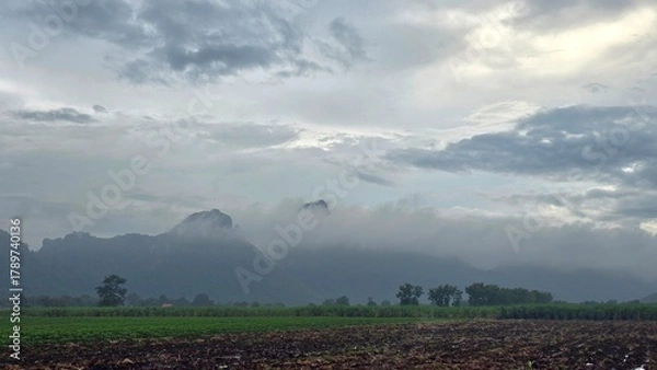 Fototapeta clouds over the field mountain