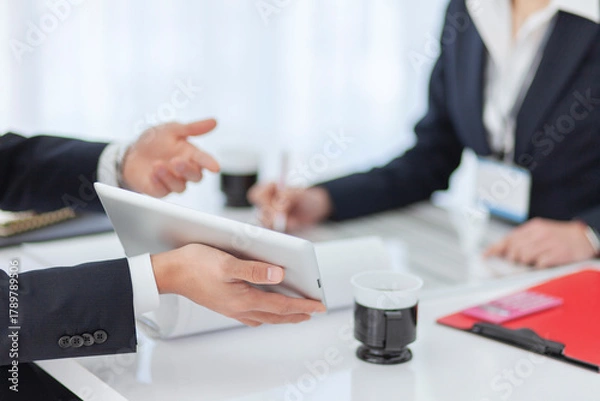 Obraz 資料を見せて打ち合わせをするビジネスマンとビジネスウーマン 