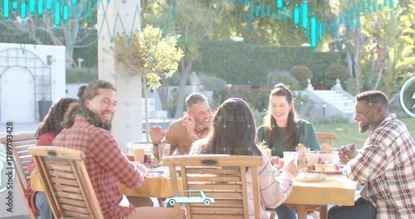 Fototapeta Laughing six adults sharing meal on backyard patio, wearing casual clothes, wooden table