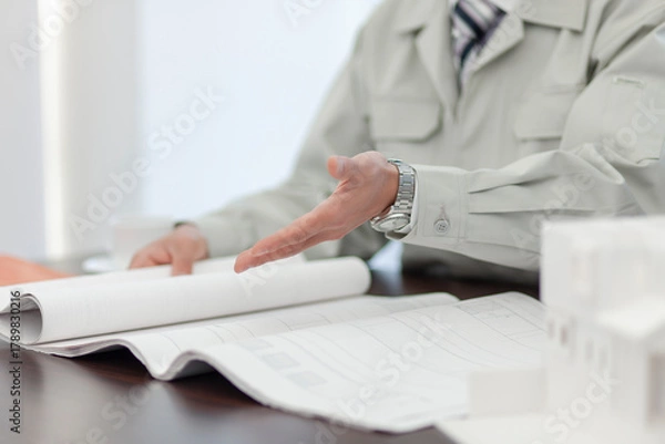 Obraz 打ち合わせをする作業着姿の男性