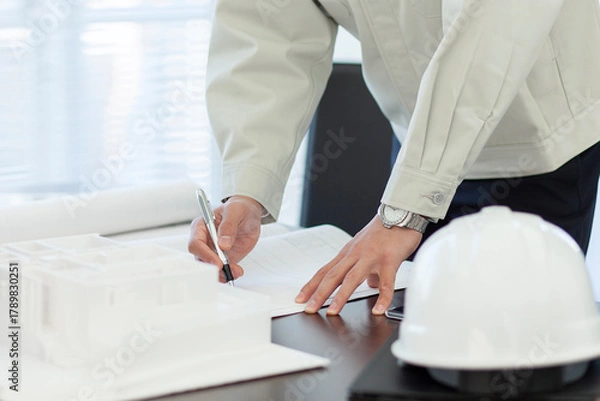 Obraz 打ち合わせをする作業着姿の男性