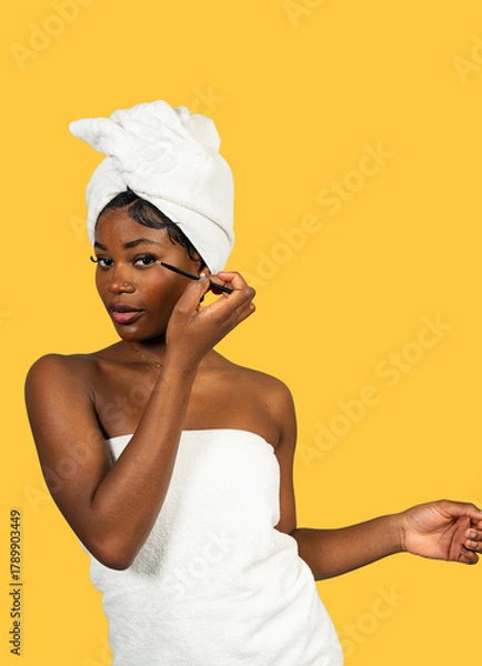 Obraz Black woman applying eyeliner for self-care routine