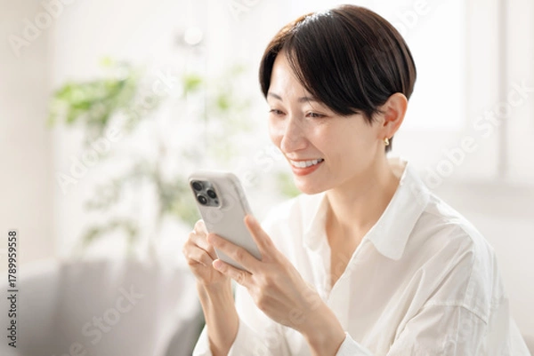 Obraz スマホを持つ女性