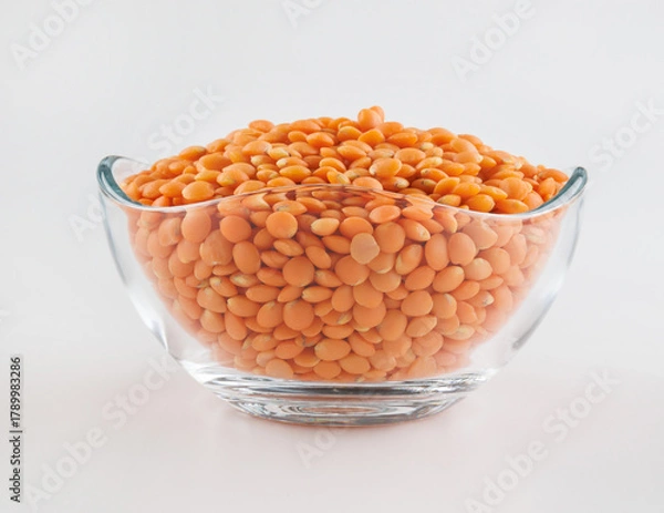 Fototapeta Glass cup with red lentils on white background. Side view.