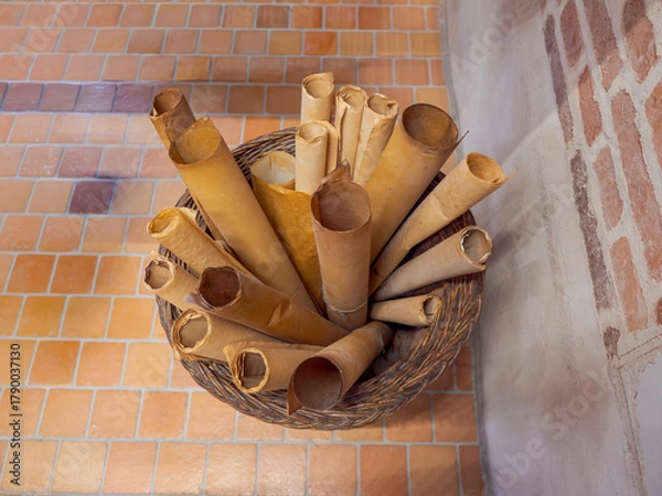 Fototapeta Old parchment scrolls in a wicker bask