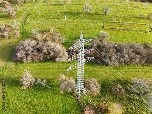 Fototapeta Aerial View of High Voltage Power Line Tower in Green Landscape
