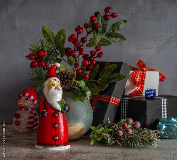 Obraz A branch with red berries and a pine branch with cones. Gift packages. Festive mood. Waiting for a Christmas miracle.