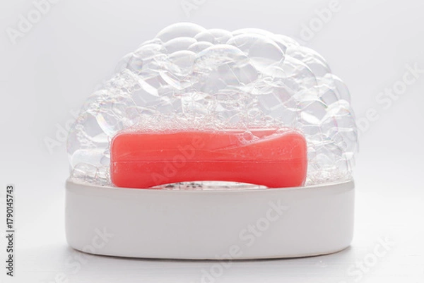 Fototapeta Red soap with soap foam on white background. Cleanness concept