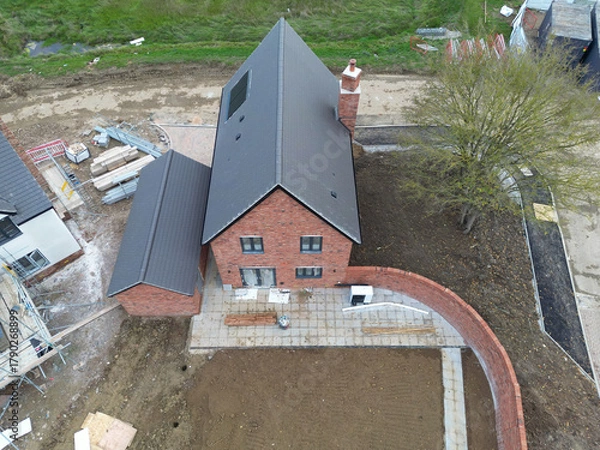 Obraz Drone view of a near completed detached family home in rural Britain. The back garden has had top soil laid, ready for grass seeding.
