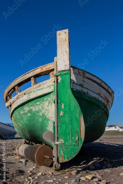 Fototapeta old abandoned wooden boat on the beach, an old shipwreck boat abandoned stand on beach or Shipwrecked off the coast of El Alquian, Almeria, Andalusia, Spain, old rusty wooden boat