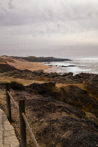 Obraz Overcast coastal view near Boca do Inferno, Portugal with rugged cliffs, sandy beach, and waves breaking along the Atlantic shore