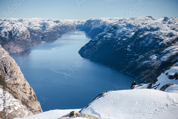 Fototapeta Skier Descending Snowy Mountain Overlooking Fjord