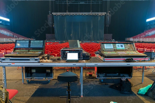 Fototapeta Sound and lighting engineers equipment set up in a concert venue before the show, ready for managing audio and visual effects during the performance