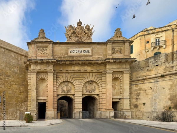 Fototapeta The monumental Victoria Gate in Valletta, Malta, a historical stone archway and fortification built during the British period, featuring intricate heraldic crests