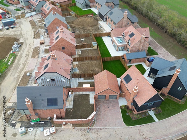 Fototapeta Aerial view of a near completed British housing estate of both first time and detached luxury family homes. Top soil can be seen laid to some of the houses back gardens.
