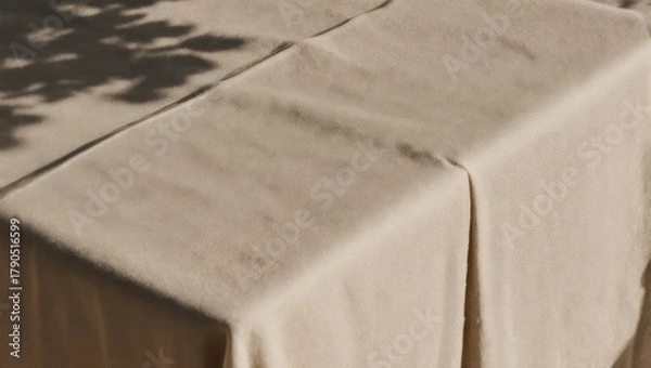 Fototapeta A close-up shot of a draped, light-colored surface, with soft shadows overhead