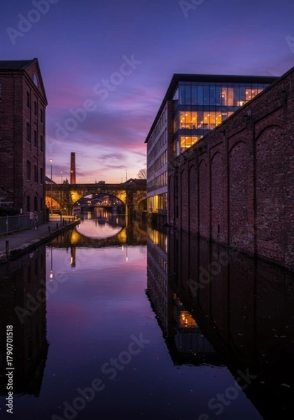 Fototapeta Canal Reflects Buildings at Dusk in Urban Cityscape
