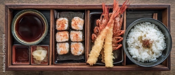 Fototapeta Overhead shot of Japanese bento box with sushi tempura shrimp rice soy sauce and ginger on wooden table restaurant setting