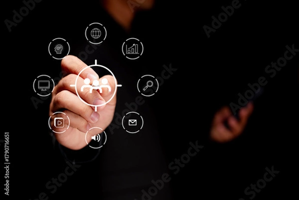 Fototapeta A person interacts with digital icons, symbolizing technology and communication in a dark environment.