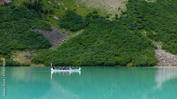 Obraz Panoramic image of a group of tourists in a canoe with a Canadian flag on Lake Louise in Banff National Park
