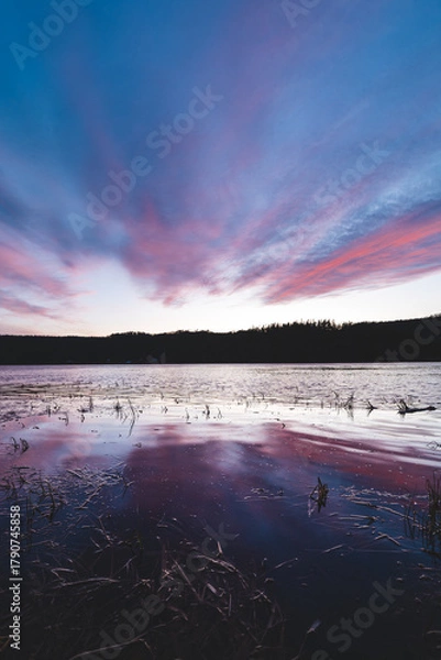 Fototapeta Soft pastel clouds reflect in calm lake water during sunset in Setesdal Valley, Norway. Peaceful Scandinavian evening atmosphere full of serenity and natural beauty
