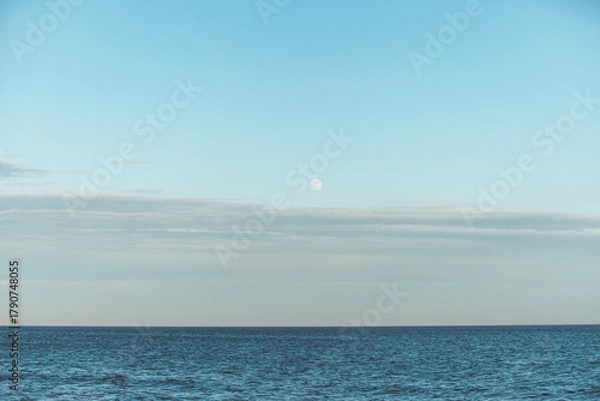 Obraz Full moon rising over the calm waters of the North Sea near Skagen, Denmark. Minimalist Scandinavian seascape bathed in soft blue light