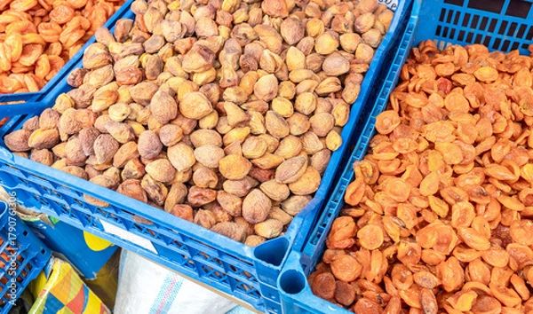 Fototapeta Organic dried apricots in plastic crates at a farmers market. Large pile of dried apricots, dried fruits, healthy dessert, vegetarian food