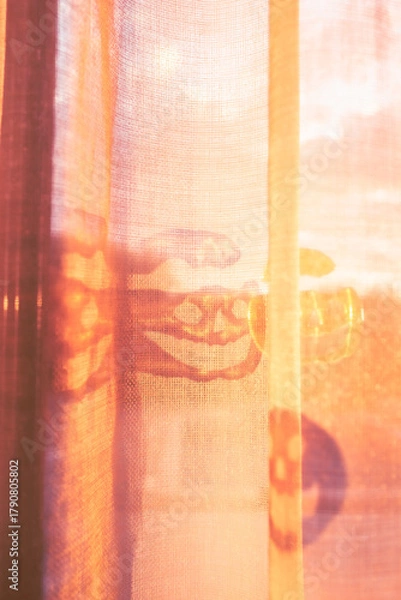 Obraz Warm sunlight illuminating sheer curtains with Halloween sticker shadows