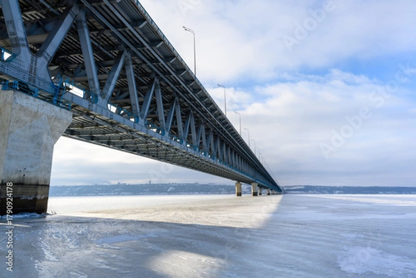 Fototapeta Presidential Bridge close-up against the backdrop of endless ice at the widest point of the Volga River near Ulyanovsk.