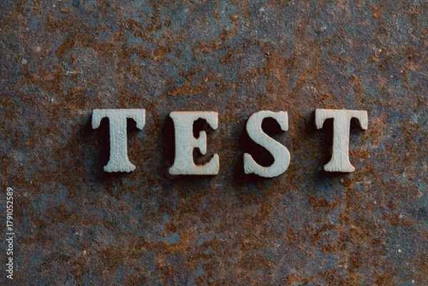Fototapeta Wooden letters with the word test on an old rusty surface, closeup, top view. Business and test concept
