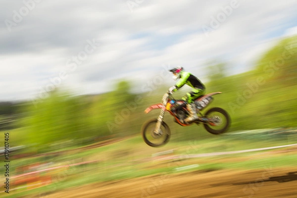 Fototapeta Biker on motocross jump in motion