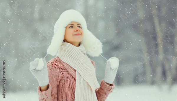 Fototapeta Happy smiling young woman in winter day, joyful girl in white hat, sweater enjoys warm weather