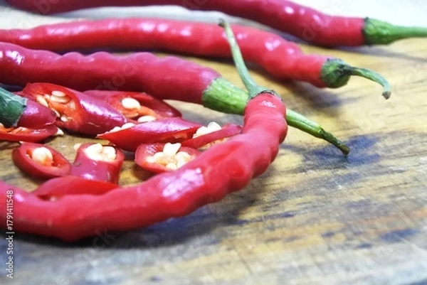 Obraz The fresh curly red chilies or capsicum annuum on an old wooden cutting board
