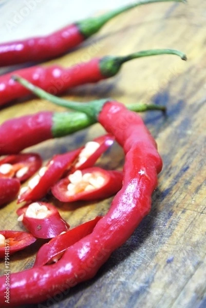 Obraz The fresh curly red chilies or capsicum annuum on an old wooden cutting board