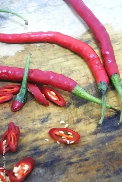 Obraz The fresh curly red chilies or capsicum annuum on an old wooden cutting board