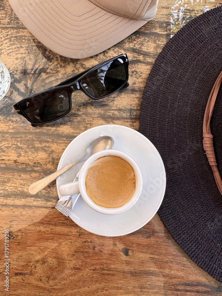 Obraz directly above shot of espresso macchiato coffee on table with sunglasses and hat at a cafe