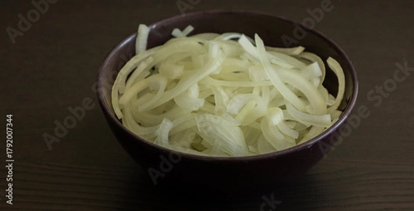 Fototapeta onion slices in dark bowl on dark table