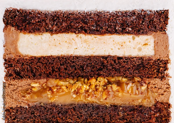 Fototapeta Layers of rich chocolate cake with creamy filling and caramel