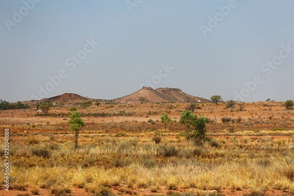 Obraz Small hills  and flat landscape in the savannah of the Northern Territory of Australia, with dry grass and small shrubs.