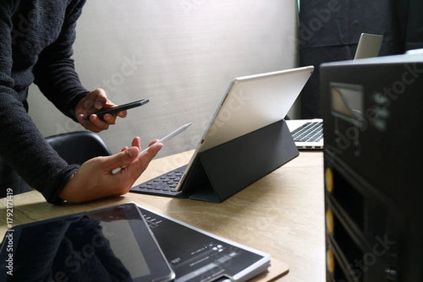 Obraz Designer using tablet and smartphone in modern workspace