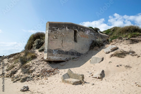 Fototapeta Effondrement d'un bunker de la Seconde Guerre mondiale dû à l'érosion au nord de la France sur la côte d'Opale. A marée basse par un temps ensoleillé. Pas-de-Calais, Hauts-de-France, France.