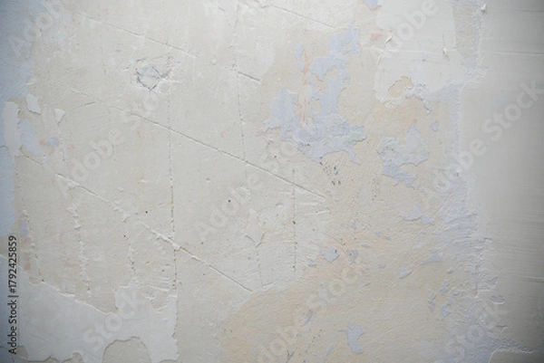 Fototapeta Textured wall surface showing peeling paint and plaster