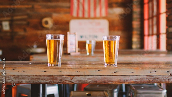 Fototapeta Glasses Of Beer On Table In Empty American Sports Bar