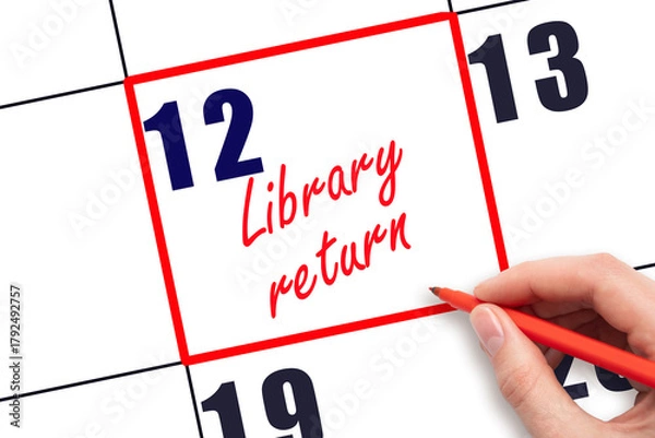 Fototapeta 12 th day of the month. Hand writing Library return reminder and drawing red frame on calendar with red pen on white background. Reading concept. Planning and scheduling