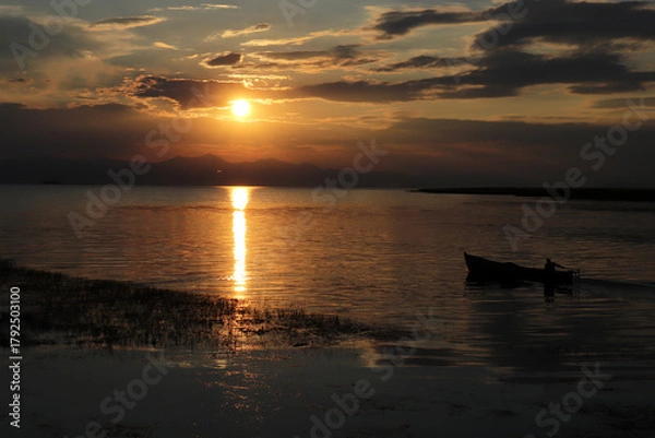 Obraz A fisherman with his boat at sunset