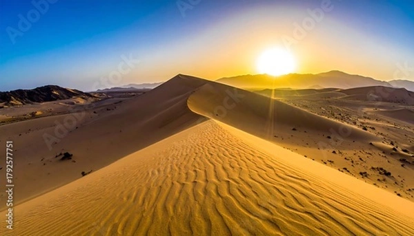 Obraz Desert landscape with golden dunes under a sunny sky with mountain range silhouette on the horizon
